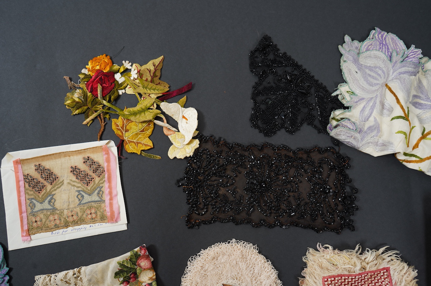 A French tortoiseshell, net, sequin and Honiton bobbin lace fan, with a collection of Jet appliques, a bead work fronter, embroidered mats and silk mats, an early Tiffany &Co poshette and embroidered appliqués and a Le M